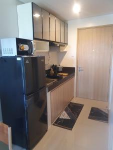a kitchen with a black refrigerator and a microwave at Hector's Place at SMDC Vine Residences in Manila