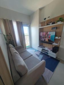 a living room with a couch and a television at Hector's Place at SMDC Vine Residences in Manila