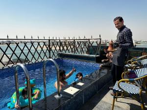 a man standing next to a swimming pool at منتجع اووه يامال البحري في الخيران OOh Yaa Mal in Al Khīrān