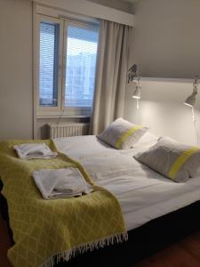 a bedroom with a bed with two pillows and a window at Kajo Lomahuoneisto in Rovaniemi