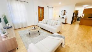 a living room with two white couches and a table at Luxury Modern Home in Summerstrand