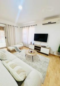 a living room with a couch and a tv at Luxury Modern Home in Summerstrand