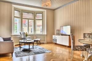 a living room with a table and chairs and a tv at Milosrdnych Apartments in Prague