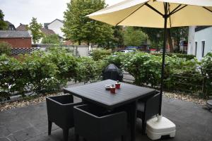 una mesa y sillas con una sombrilla en el patio en MyHome-Tiny -stilvollen Ruhepol en Lüdinghausen