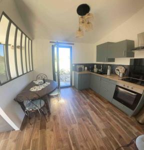 een keuken met een tafel en een houten vloer bij Studio Nîmes in Nîmes