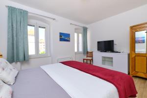 木洛希尼Villa Sommerzauber的卧室里有一张白色的床和一台电视