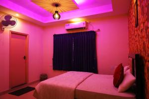 バンガロールにあるUrban Stay Adams Service Apartmentのピンクのベッドルーム1室(ベッド1台付)