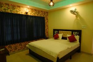 バンガロールにあるUrban Stay Adams Service Apartmentのベッドルーム1室(赤い枕のベッド1台付)