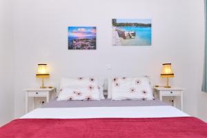 木洛希尼Villa Sommerzauber的卧室配有带两盏灯的白色床