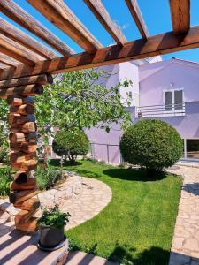 木洛希尼Villa Sommerzauber的一个带木制凉棚的花园