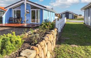 a blue house with a stone wall in front of a yard at Friedrichskoog-deichblick 4 in Friedrichskoog