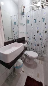 La salle de bains blanche est pourvue d'un lavabo et de toilettes. dans l'établissement Appartement Belle Paris - Beira Mar Praia do Francês, à Marechal Deodoro
