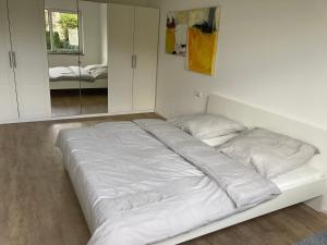 a white bed in a room with a mirror at 70 qm Wohnung in Weinstadt Strümpfelbach in Weinstadt +5 photos