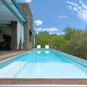 uma grande piscina azul numa casa em Kruger River Villas - LionsGate em Marloth Park