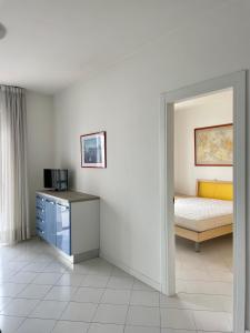 Habitación con 1 dormitorio con 1 cama y microondas. en Residence la Duna 5D, en Lignano Sabbiadoro