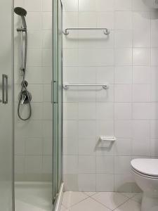 y baño con ducha y aseo. en Residence la Duna 5D, en Lignano Sabbiadoro