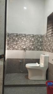 a bathroom with a toilet in a room at आंगण होम स्टे in Malvan