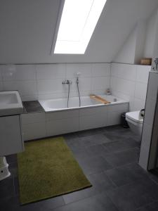 a bathroom with a tub and a sink and a toilet at Nordseehus-HYGGE in Butjadingen