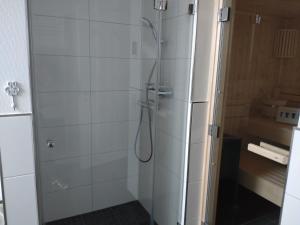 a shower with a glass door in a bathroom at Nordseehus-HYGGE in Butjadingen