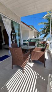 une terrasse couverte avec une table et des chaises. dans l'établissement Appartement Belle Paris - Beira Mar Praia do Francês, à Marechal Deodoro