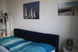 a bedroom with a bed and a picture of sailboats at frische Brise in Flensburg