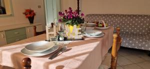 una mesa de comedor con un mantel blanco y flores en Casa Anna Arezzo, en Quarata