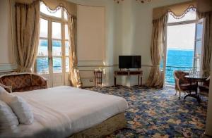 a bedroom with a bed and a television and a window at Windsor Palace Luxury Heritage Hotel Since 1906 by Paradise Inn Group in Alexandria