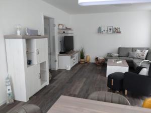 a living room with a couch and a tv at Nordseehus-HYGGE in Butjadingen