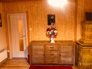 a wooden cabinet with a vase of flowers on it at Chata Safran in Donovaly