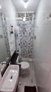La salle de bains blanche est pourvue de toilettes et d'un lavabo. dans l'établissement Appartement Belle Paris - Beira Mar Praia do Francês, à Marechal Deodoro