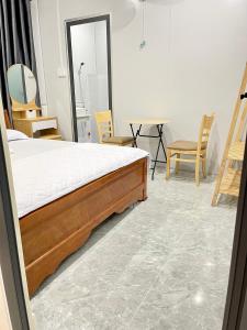 a bedroom with a bed and a table and chairs at Hà Linh Motel in Vung Tau