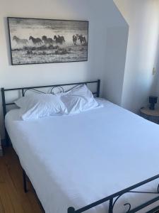 Duas camas num quarto com uma fotografia de cavalos em Maison Bord de Mer em Dieppe