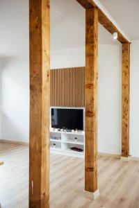 uma sala de estar com televisão e vigas de madeira em VILLA MEDI boutique em Sapareva Banya