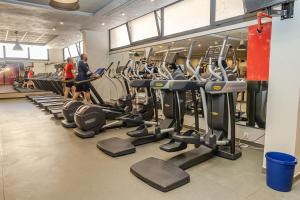 a gym with rows of tread machines and people walking around at Liberté Hotels Oran in Oran
