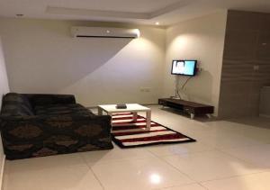 uma sala de estar com um sofá e uma televisão em شقق فاخريه جده em Jidá