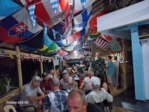 una multitud de personas sentadas en un bar con sombrillas en Olivers Binucot Beach House en Romblon