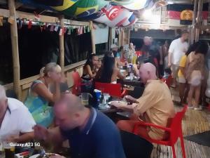 a group of people sitting at tables in a restaurant at Olivers Binucot Beach House in Romblon