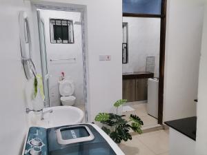 ein Badezimmer mit einer Badewanne, einem WC und einem Waschbecken in der Unterkunft Millan Homes in Mombasa