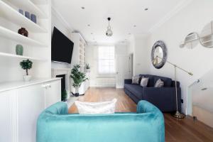 a living room with a blue chair and a couch at Beautiful 4 Bedroom House near Paddington Station in London