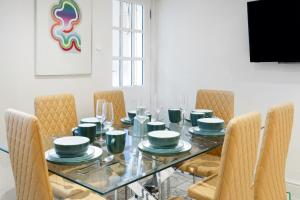 a dining room with a glass table and chairs at Beautiful 4 Bedroom House near Paddington Station in London