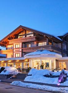 a large building with snow in front of it at Hotel Rosenstock - Erwachsenenhotel - Adults only 15 plus in Fischen