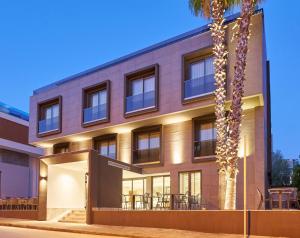 ein Gebäude mit einer Palme davor in der Unterkunft La Maja Hotel in Antalya