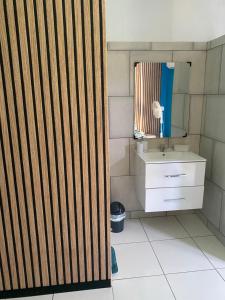 - une salle de bains avec une porte coulissante en bois à côté d'un lavabo dans l'établissement Le Domaine de l'Étang, à Saint-André