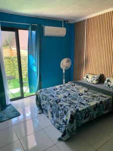 1 dormitorio con cama y pared azul en Le Domaine de l'Étang en Saint-André