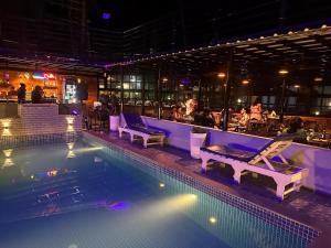 a pool with lounge chairs and a bar at night at JW HERITAGE in Anjuna