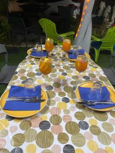 een tafel met blauwe borden en glazen sinaasappelsap bij Le Domaine de l'Étang in Saint-André
