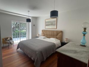 ein Schlafzimmer mit einem Bett und einem großen Fenster in der Unterkunft Preciosa casa entre Lisboa, Cascais y Sintra in Fuente el Saz