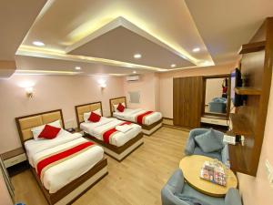 Habitación de hotel con 2 camas, mesa y sillas en Hotel White Rabbit en Katmandú