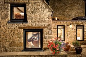 a stone building with windows and a bouquet of flowers at Bantam Tea Rooms in Chipping Campden