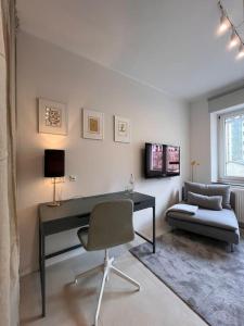 Habitación con escritorio, silla y sofá. en Quiet and sunny studio in Ddorf absolut city center, en Düsseldorf